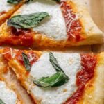 Freshly baked pizza with a golden greek yogurt pizza dough crust on a wooden board