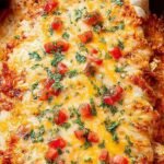 A baking dish filled with cheesy healthy chicken enchiladas topped with fresh cilantro