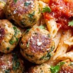 Golden brown air fryer chicken meatballs garnished with fresh parsley on a white plate