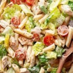 A bowl of healthy chicken caesar pasta salad with grilled chicken, romaine lettuce, and whole wheat penne.