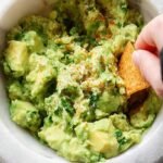 A bowl of fresh green 4-ingredient guacamole with cilantro on top