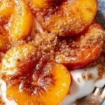 Halved peaches with cinnamon sugar topping in an air fryer basket