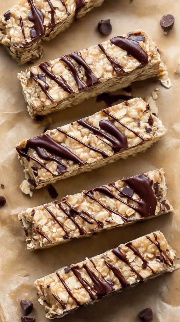 A stack of homemade nut-free protein bars with mini chocolate chips on a parchment-lined tray.