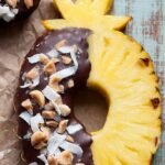 Fresh pineapple wedges dipped in dark chocolate with sea salt on a baking sheet