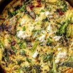 A golden brown air fryer frittata sliced into wedges in a small round pan