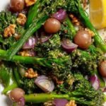 A bowl of creamy broccolini salad with bacon, dried cranberries, and sunflower seeds.