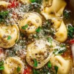 A steaming bowl of parmesan kale tortellini soup with fresh greens and cheesy pasta