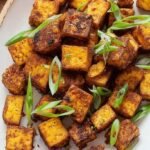 Golden brown cubes of super crispy tofu in a bowl with dipping sauce