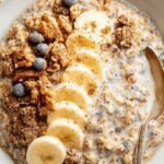 A glass jar filled with creamy cinnamon overnight oats topped with a dash of extra cinnamon