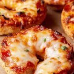 A plate of golden, crispy air fryer bagel bites with melted cheese and pepperoni.