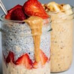 A glass jar filled with creamy overnight oats topped with fresh blueberries