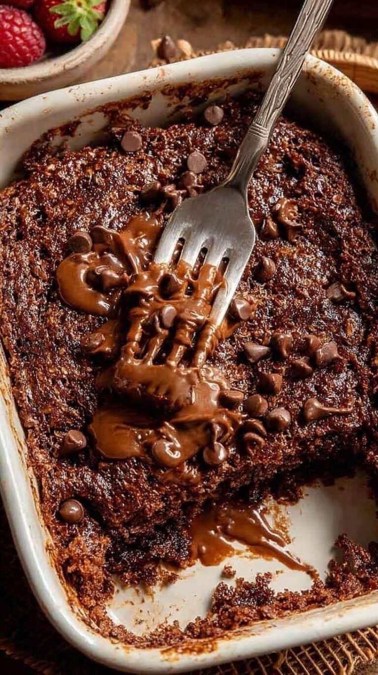 A single-serve ramekin of chocolate baked oats topped with melted chocolate chips.