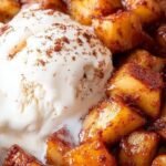 Sliced air fryer apples coated in cinnamon and brown sugar in a black air fryer basket