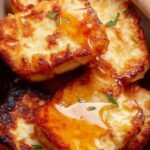 Golden brown crispy air fryer halloumi slices served with fresh lemon wedges