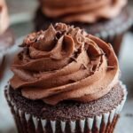 A tray of twelve moist gluten-free chocolate cupcakes with a deep cocoa color and tender crumb.