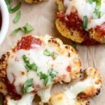 Golden brown cauliflower pizza bites topped with melted mozzarella and mini pepperoni in a muffin tin.