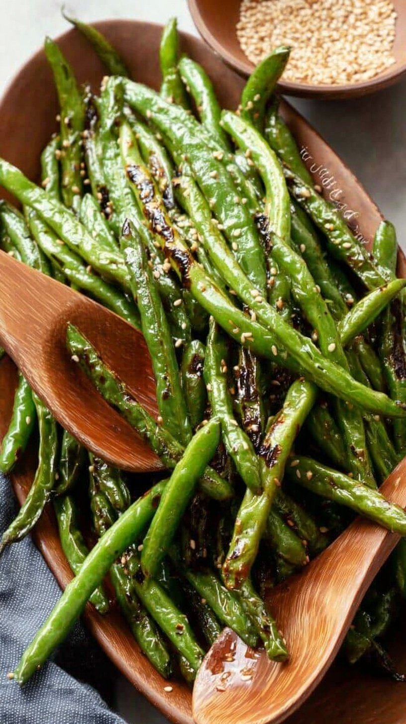 Crispy air fried green beans in a basket with garlic parmesan topping