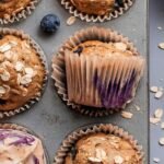 A stack of fresh blueberry banana oatmeal muffins on a wire cooling rack