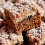 A slice of cinnamon coffee cake with an oat streusel topping on a white plate