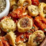 Golden brown breaded tortellini in an air fryer basket served with marinara sauce