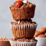 A stack of golden brown pumpkin muffins made with almond flour on a wire cooling rack