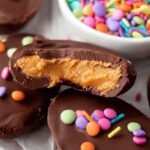 Chocolate covered healthy peanut butter eggs on a parchment lined tray