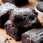 A stack of fudgy chocolate brownies made with avocado and banana on a cooling rack.