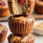 Freshly baked peanut butter banana muffins with a visible jelly center on a wire cooling rack