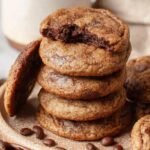 A stack of soft, chewy coffee cookies with melty chocolate chips on a wire cooling rack.