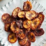 A bowl of golden, crispy air fried banana chips seasoned with turmeric