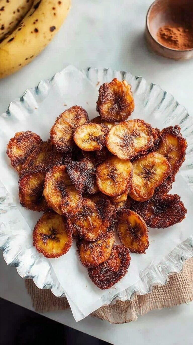 A bowl of golden, crispy air fried banana chips seasoned with turmeric