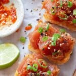 Golden fried rice blocks topped with spicy tuna, jalapeño slices, and black sesame seeds