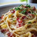 A bowl of creamy bacon pasta with fresh parsley and parmesan cheese