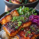 Crispy salmon cubes drizzled in spicy mayo sauce over a bowl of rice and vegetables