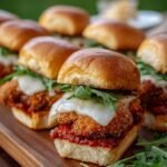 A tray of golden brown chicken parmesan sliders with melted mozzarella and garlic herb butter.