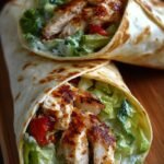 Golden brown toasted chicken wraps filled with melted cheese and garlic chicken on a white plate.