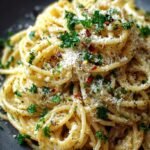 A white bowl filled with creamy gluten-free fettuccine pasta, topped with fresh parsley and grated parmesan cheese.