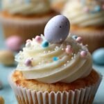 Vanilla cupcakes topped with chocolate frosting nests and colorful malted egg candies