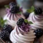 A tray of light purple marbled mini meringues on parchment paper