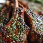 Pan-seared garlic herb lamb chops in a cast iron skillet with fresh rosemary and melted butter.