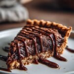 A golden brown deep-dish chocolate chip cookie pie sliced to reveal a thick molten Nutella center