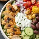 A vibrant Greek Chicken Power Bowl with grilled chicken, quinoa, tomatoes, cucumbers, and feta cheese