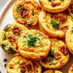 Close up of golden brown bacon and Gruyère egg bites in a silicone tray