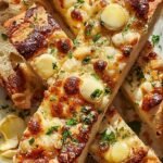 Golden brown cheesy breadsticks with garlic butter and parsley on a baking sheet