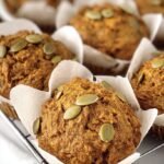 Freshly baked whole wheat pumpkin muffins sitting on a wire cooling rack.