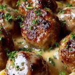 Juicy pan-seared meatballs glazed in a golden garlic butter sauce in a skillet