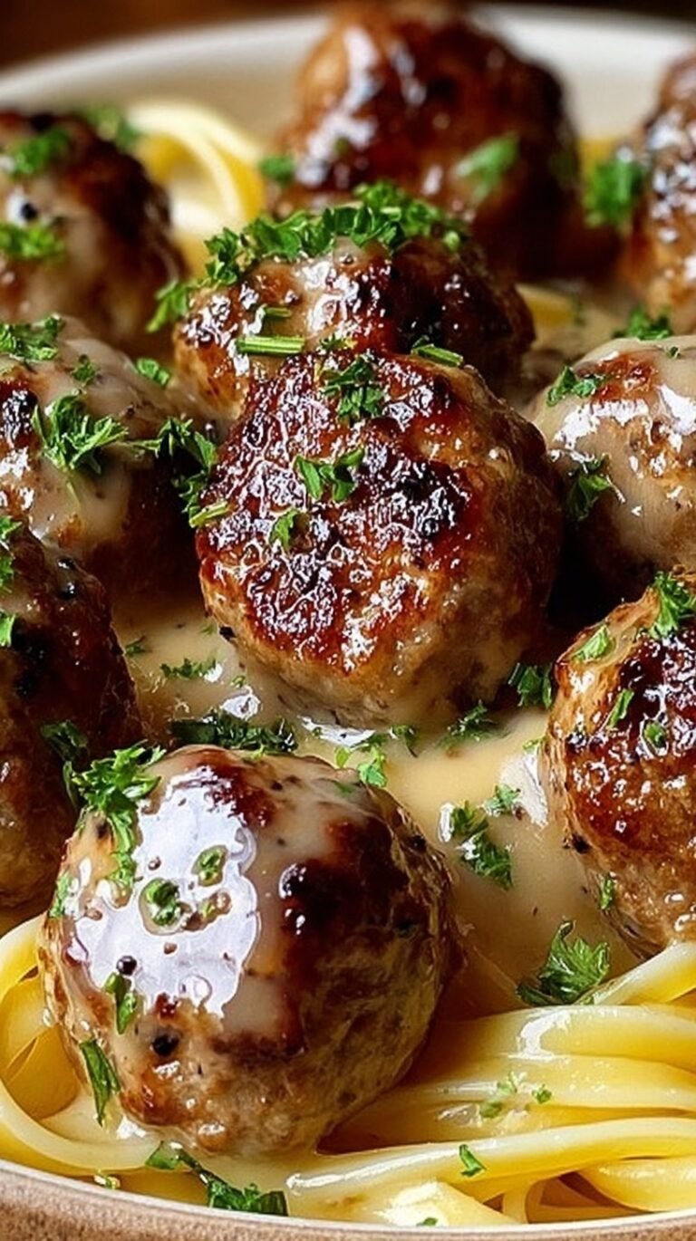 Juicy pan-seared meatballs glazed in a golden garlic butter sauce in a skillet