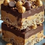 A stack of square chocolate-topped peanut butter bars on parchment paper
