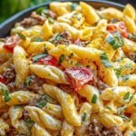 A large bowl of Big Mac Pasta Salad with ground beef, cheese, and pickles