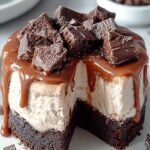 A sliced frozen brownie ice cream cake with layers of vanilla and chocolate ice cream and a chocolate ganache topping